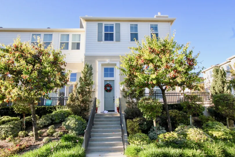 a warm day in the kensington court with house that has steps and entrance in the center and garden on the both side