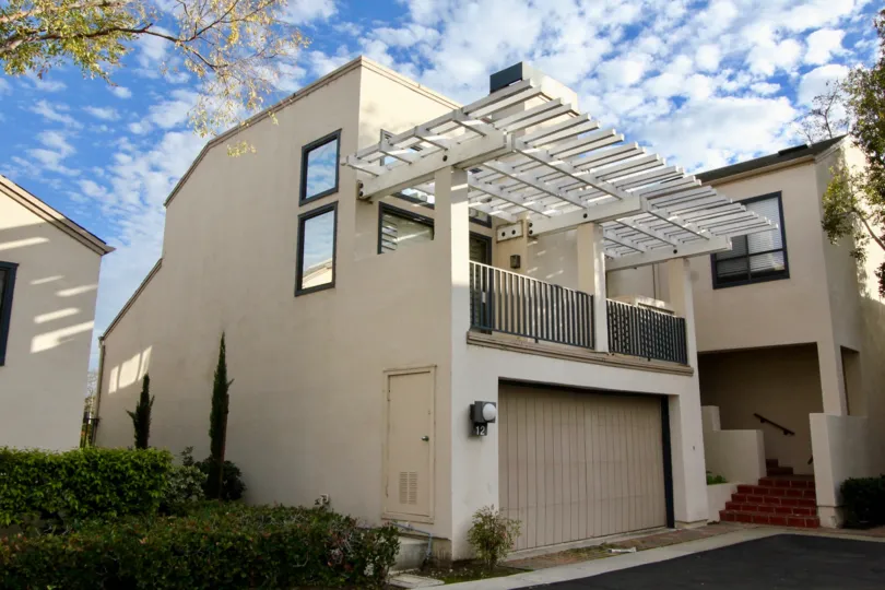 a warm day in the lakeshore with a building that has parking door closed and steps in right and garden both side