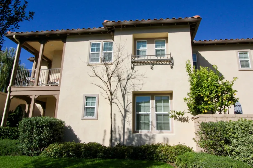 THE SIDEVIEW OF THE HOUSE WITH LAWN, PLANTS, TREES SITUATED IN IRVINE CITY