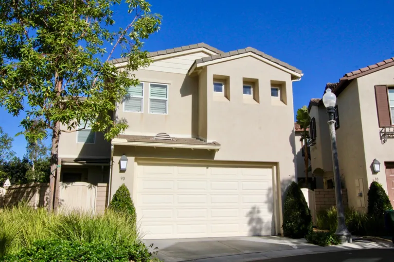 THE FRONT VIEW OF HOUSE WITH SHED, LIGHT LAMP, PLANTS, TREES WHICH IS SITUATED IN CITY OF IRVINE
