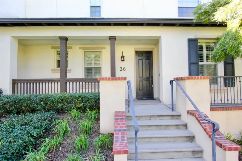 a pleasant day in the lombard court with a house that has numbered as 36 and steps in center and garden in left side