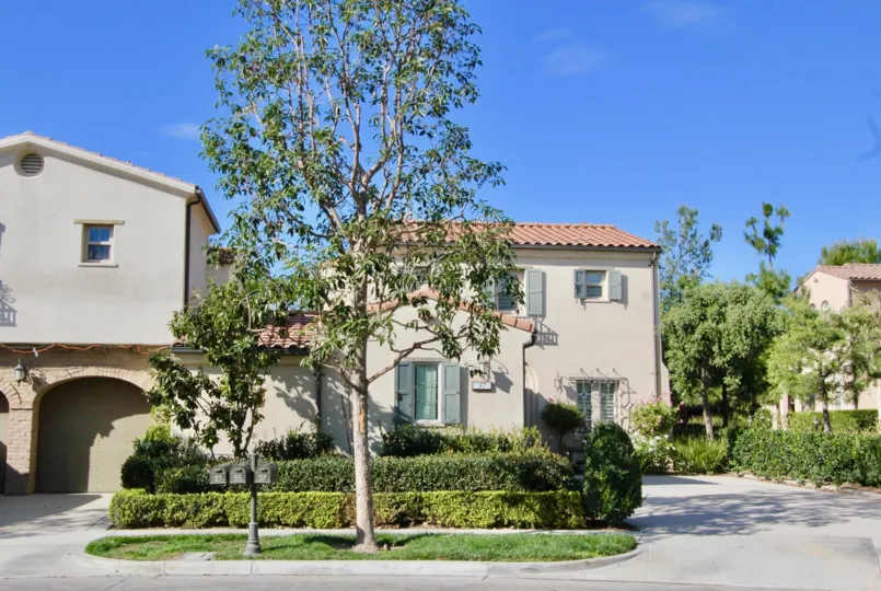A traditional two-storey housing in the Los Arboles community with blue shutters and orange roofs.