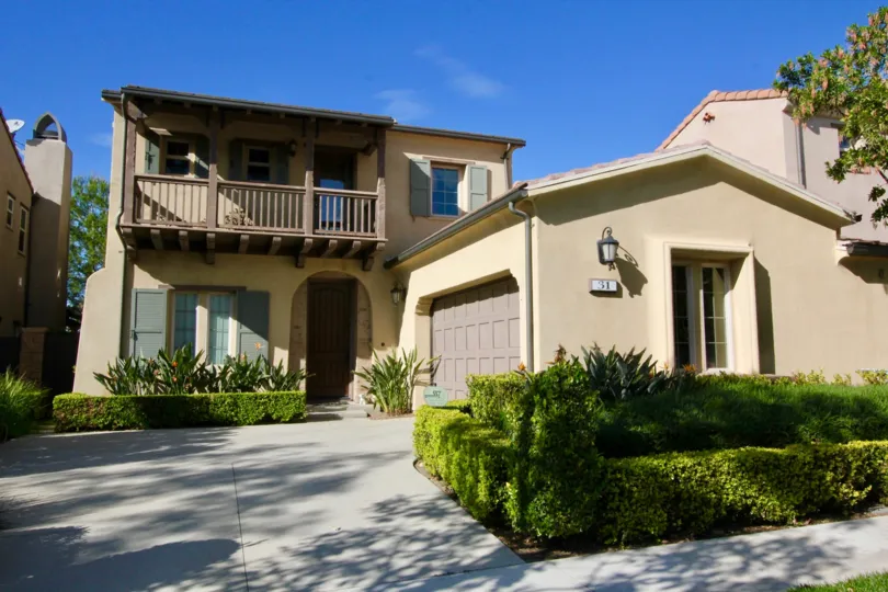 THE FRONT VIEW OF VILLA WITH THE MANY PLANTS WHICH IS IN LOS ARBOLES COMMUNITY
