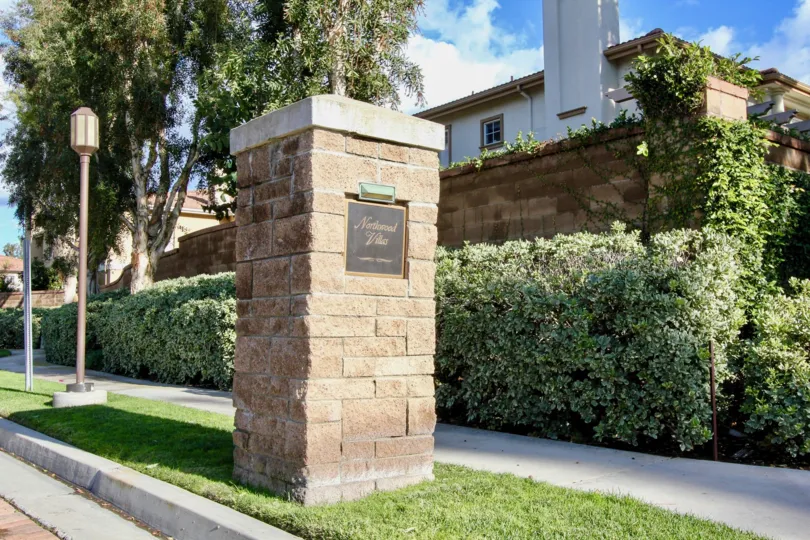 a warm day in the northwood pointe with a building that has stone walls and lamp post and garden around