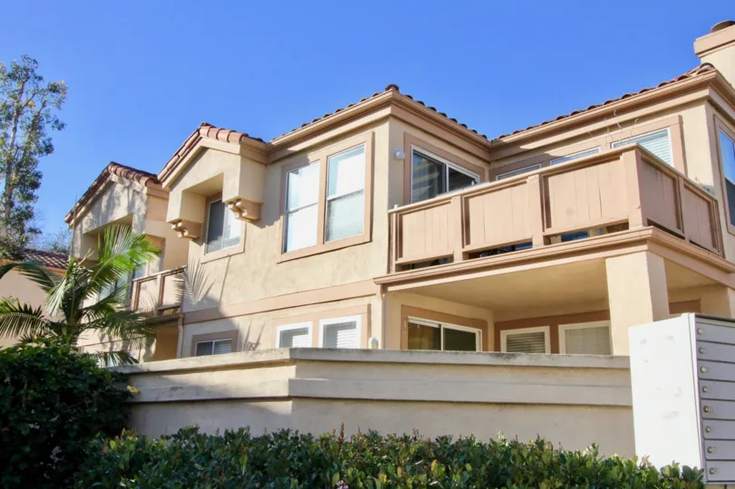 a warm day in the northwood villas with a building that has roofless top and parking door closed and garden around