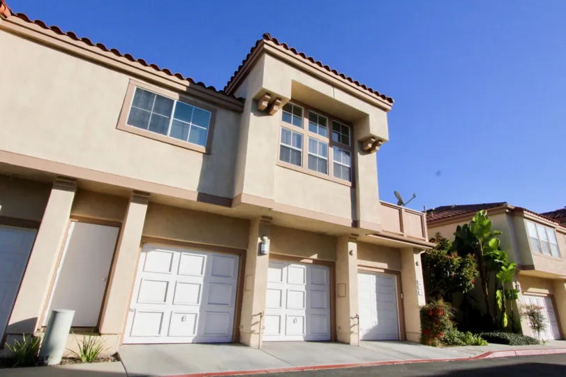 A two-storey townhouse in the Northwood Villas community with three carport and decorative dormer windows.