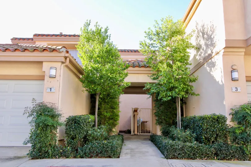 A sidewalk surrounded by trees and plants inside Norhtwood Villas in Irvine CA