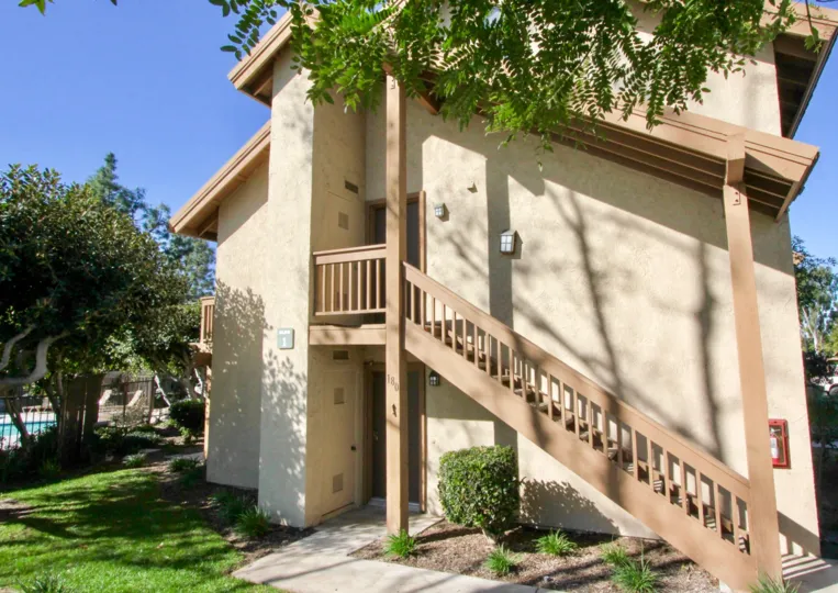 Side of condos with staircase and doors on building at Orangetree Lake Condos community in Irvine, California