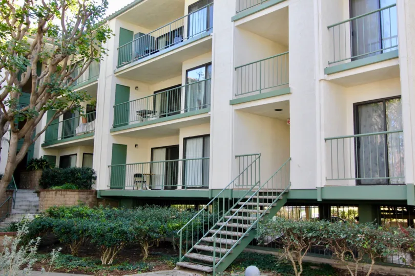 Three story condominium building with attached green stairs inside Orangetree Terrace in Irvine CA