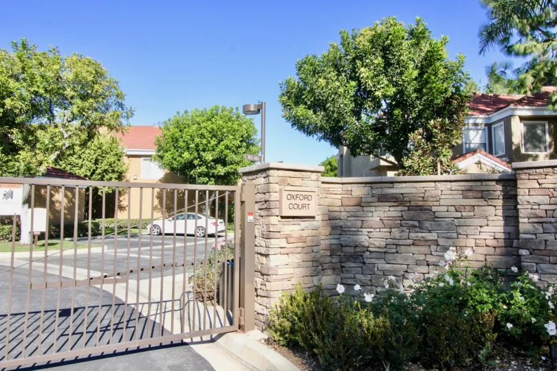 Security gate near a brick wall at the entrance of Oxford Court in Irvine California