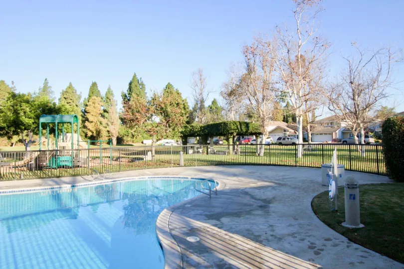 a warn day in the park homes with a park that has swiming pool clearness and garden around