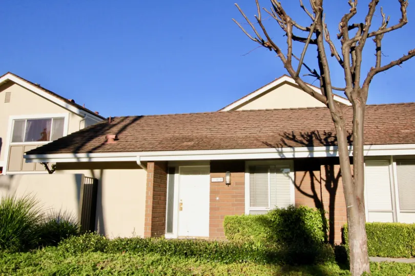 a warm day in the park homes with a building that has roofless top and parking 2 door closed and garden around