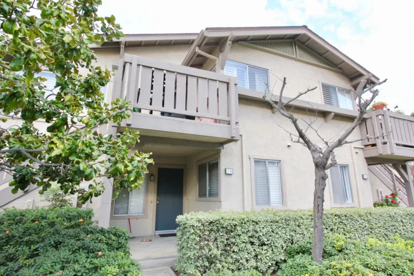 Front to the Villa in Park Vista has Dry tree centered between bushes and plants