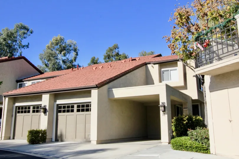 A driving leading up to a condominium with a covered entrance at Princeton Townhomes in Irvine CA
