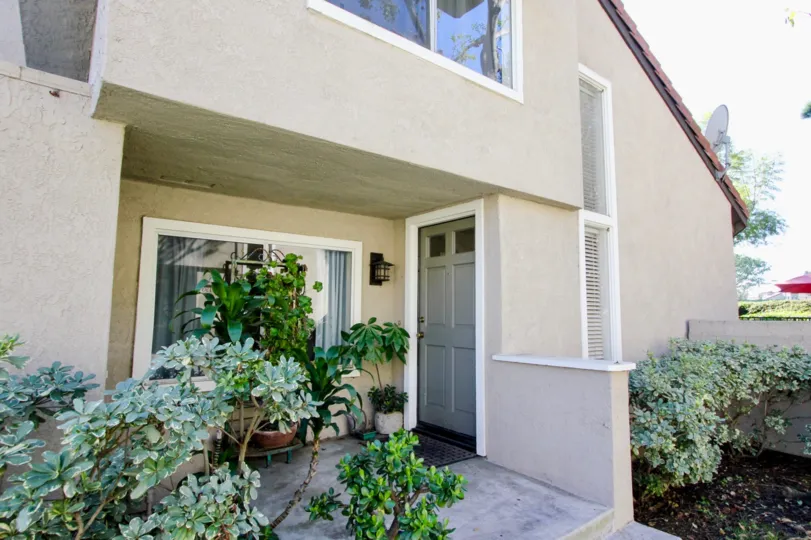 THE HOME IN THE PRINCETON TOWNHOMES WITH THE FLOWERPOTS, PLANTS, DISH ANTENNA