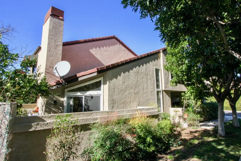 THE BUILDING IN THE PRINCETON TOWNHOMES WITH THE DISH ANTENNA, LAWN, TREES, PLANTS