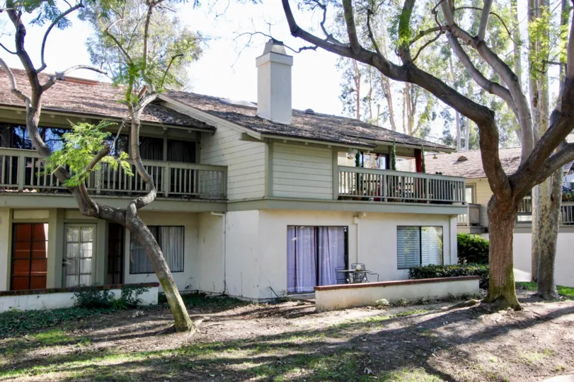 THE SIDE VIEW OF HOUSE WITH TREES PLANTS PALCONY SHED ARE THERE IN IRVINE CITY