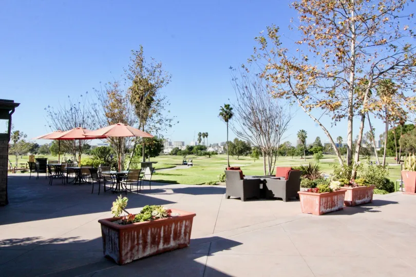 a sunny day at the golf course in the Rancho San Joaquin Townhomes with potted plants and covered tables
