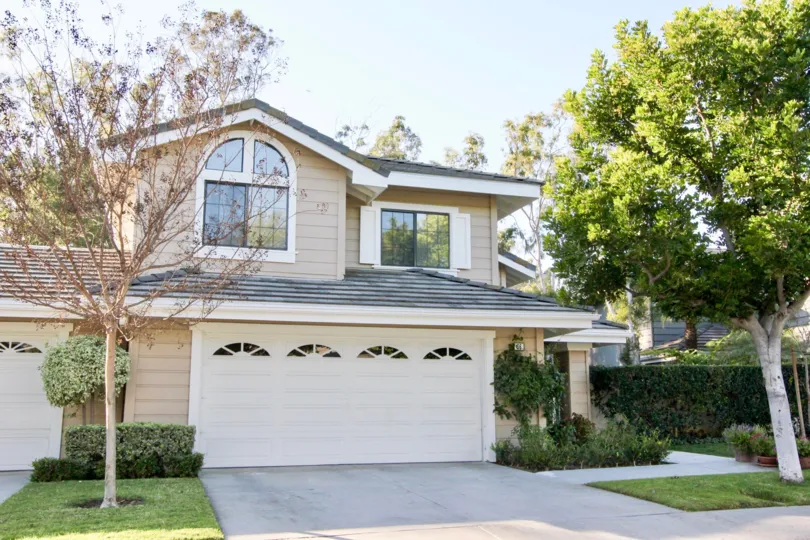 A two story home with two garages with small windows at Ridge Garden Homes in Irvine CA