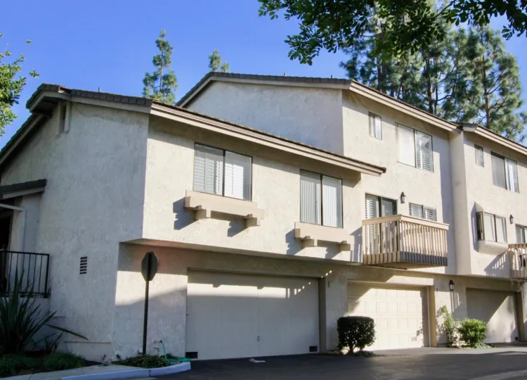A simple low-rise housing in the Ridge Townhomes Bren community with sliding windows and closed carport.