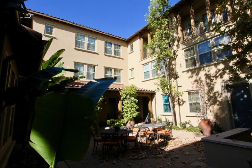 chair and tables are placed in center of the building having trees and plants around in San Carlos