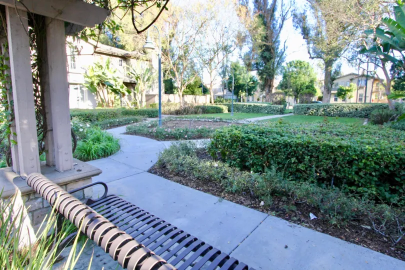 Natural Park in San Juan Bautista has seating bench with light lamp, bushes and trees