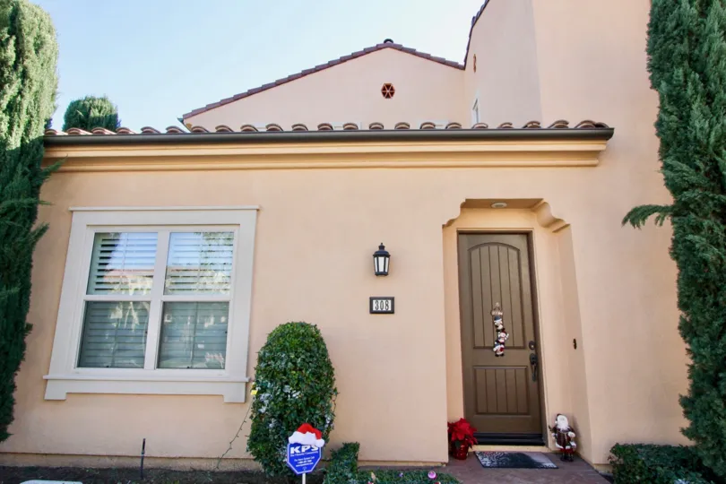 A brown wooden door on a pink home at Santa Cruz in Irvine CA
