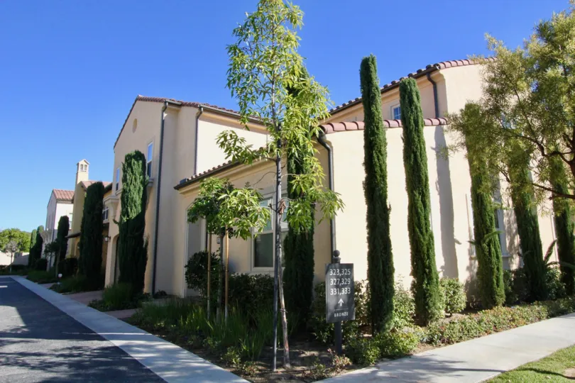 House in Santa Cruz is surrounded with few Tall trees with bushes and has street sign board
