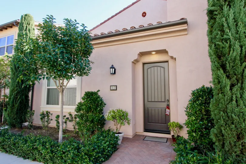 THE FRONT OF THE HOME IN IRVINE CITY, THAT HAVE THE LOT OF PLANTS, TREES ON BOTH SIDE