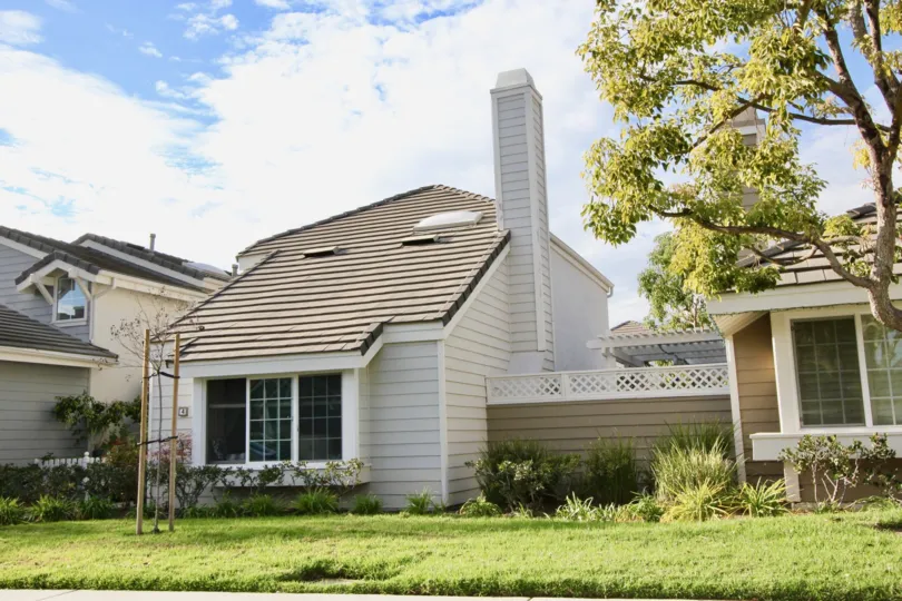 a white home with a chimney, lawn and large bay window in Seaport