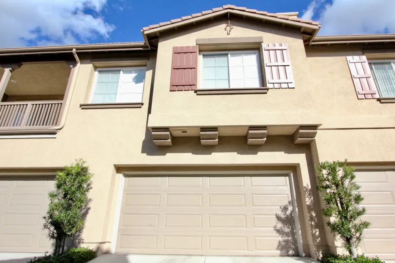 A two-storey residence in the Sheridance Place community with pink shutters and closed carport.