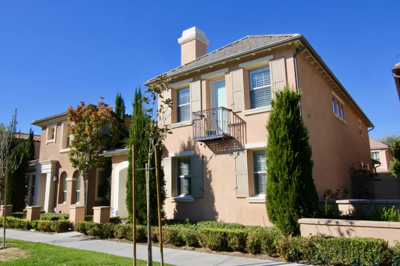 A street view of homes and landscaping on a sunny day at Stonetree Manor