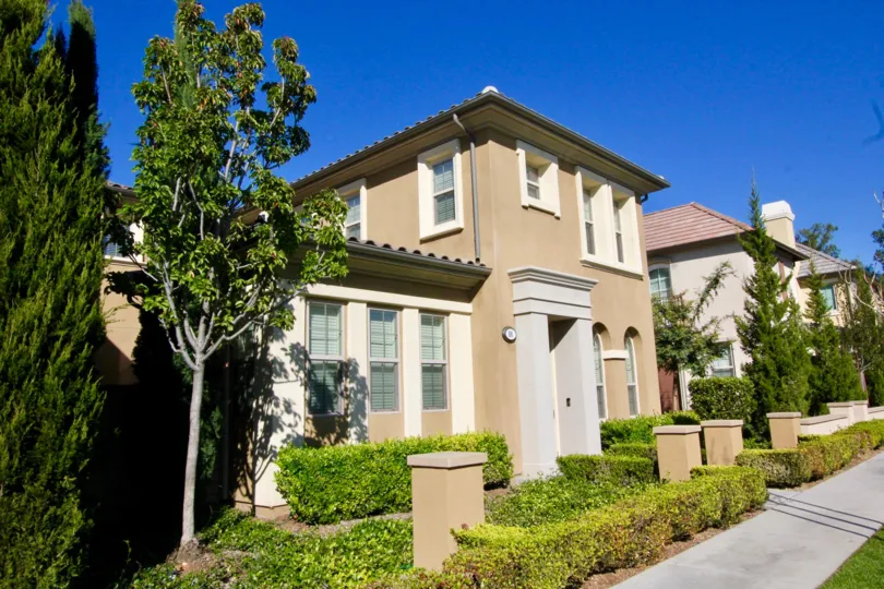 A two story brown home with a gray archway entrance inside Stonetree Manor in Irvine CA
