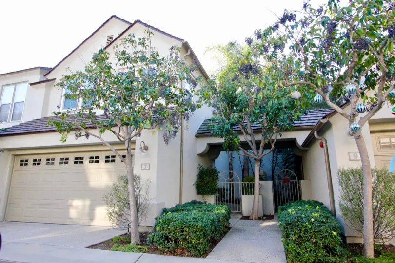 THIS IMAGE VIEWS THE FRONT OF HOME WITH SHED IN IRVINE, THAT SHOWS PLANTS AND TREES