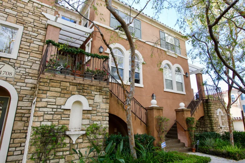 A three-storey townhouse in Terra Bella community with stone cladding and brownish walls.