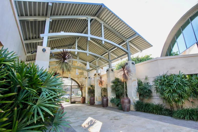 THIS IMAGE VIEWS THE ENTRANCE WAY TO THE HOME THAT HAS THE PLANTS AND TREES WHICH IS SITUATED IN THE CITY OF IRVINE