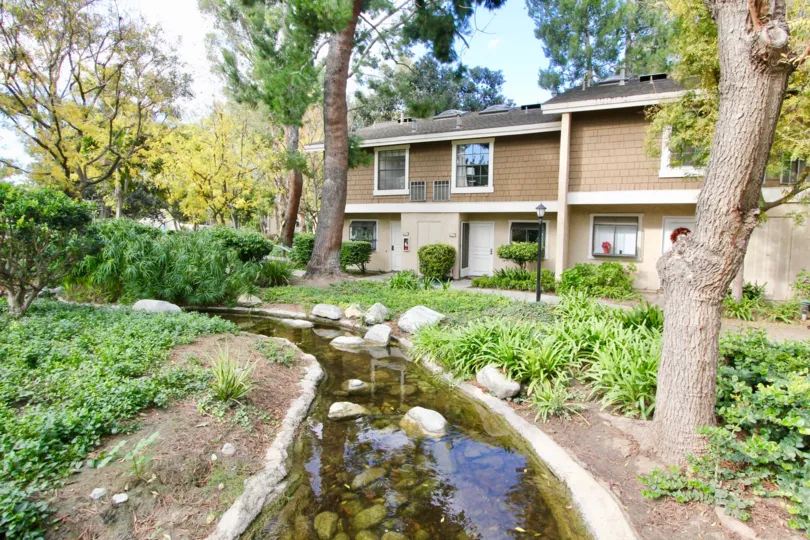 Narrow little waterway leading through a garden area at The Lakes in Irvine CA