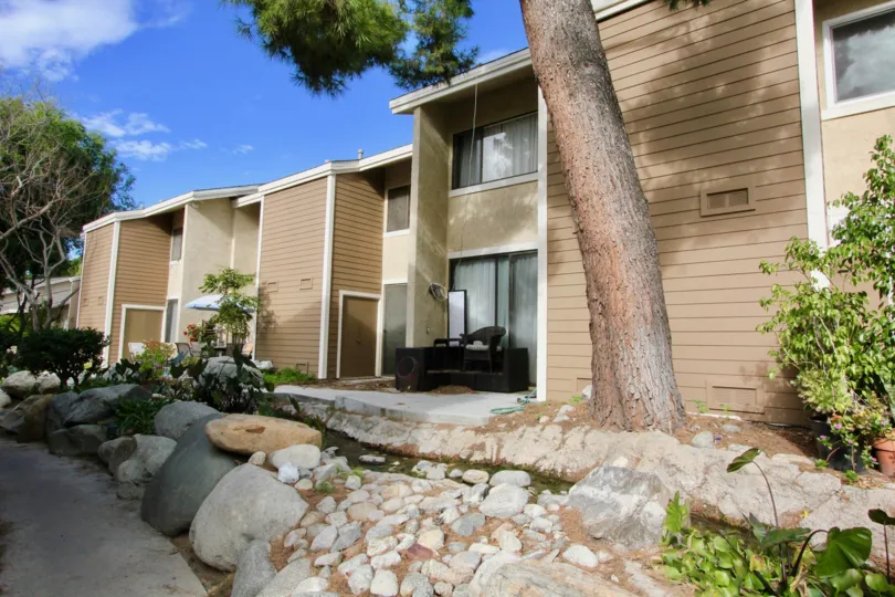 Townhomes with a bright blue sky and white clouds in The Lakes community of Irvine, California