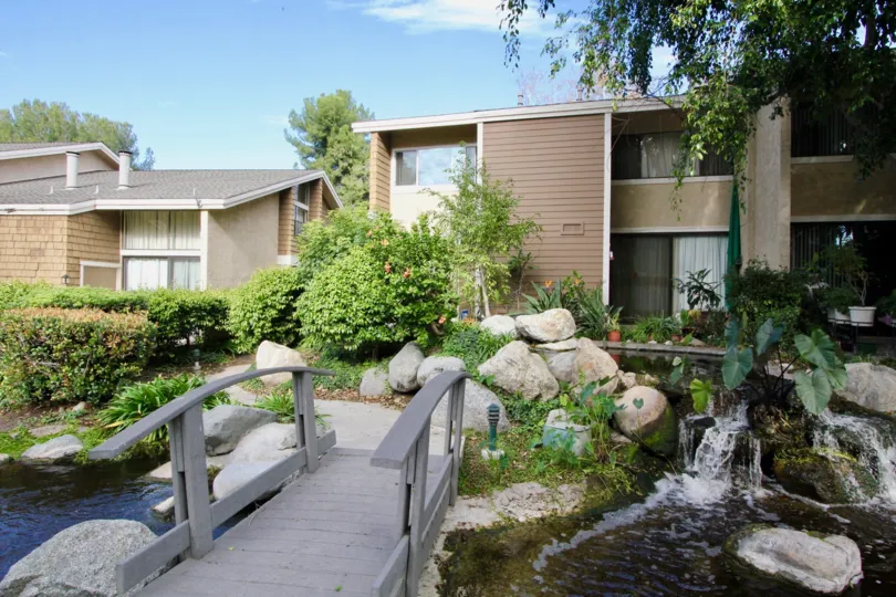 Awesome view of bridge with plants and trees near villas in The Lakes of Irvine