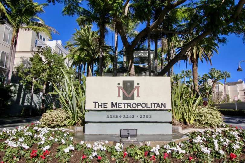 A sunny day in the area of The Metropolitan, outside, palm trees, welcome sign, high rise, condo