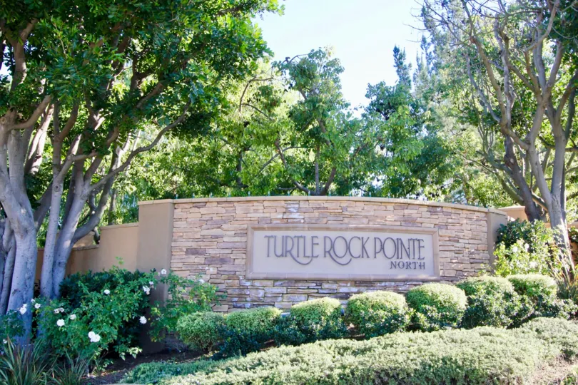 A large pink stone sign at the entrance of Turtle Rock Point in Irvine CA