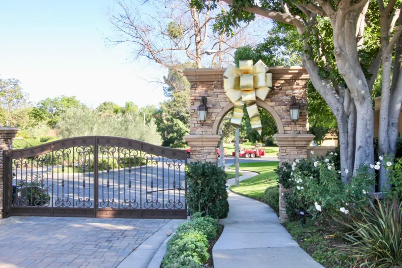 A large, golden bow sits over an archway at the Turtle Rock Pointe community.