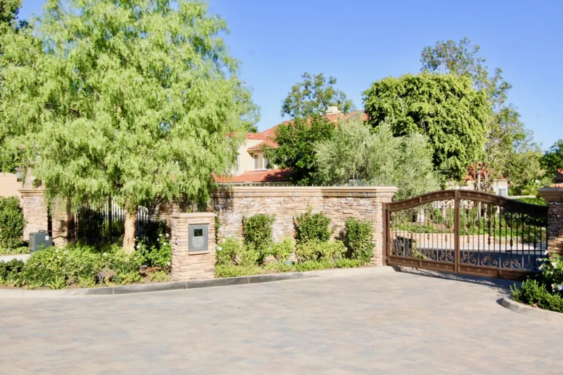 gate driveway tree garden western west coast sun outdoors upperclass fancy stone fence metal