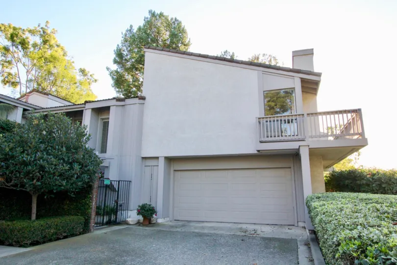Front of a beige house with empty driveway in Turtle Rock Vista community in Irvine, California