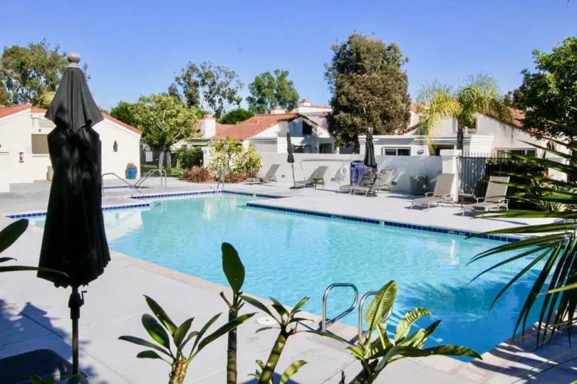 Large blue swimming pool surrounded by condos inside Villas at RSJ in Irvine CA