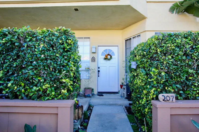 A front entrance with tall shrubs in the Vista West Park community.