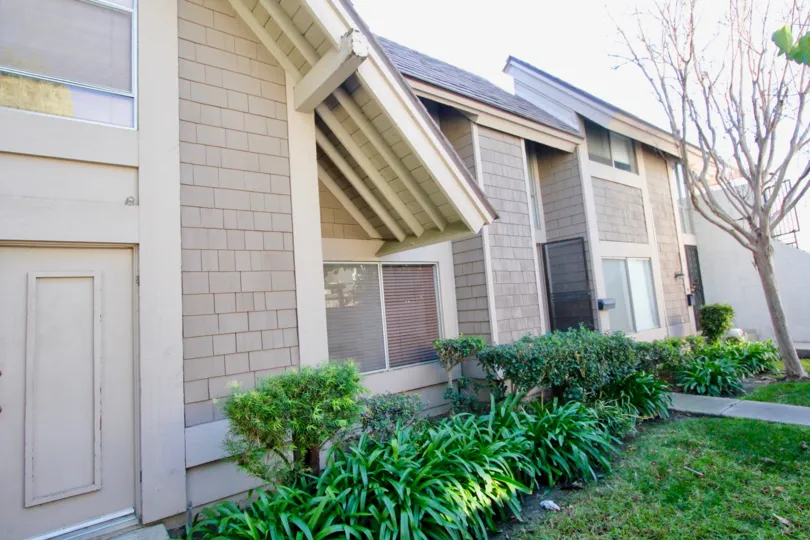 A home in Walnut Square showing the trees and exterior shrubs and walkway