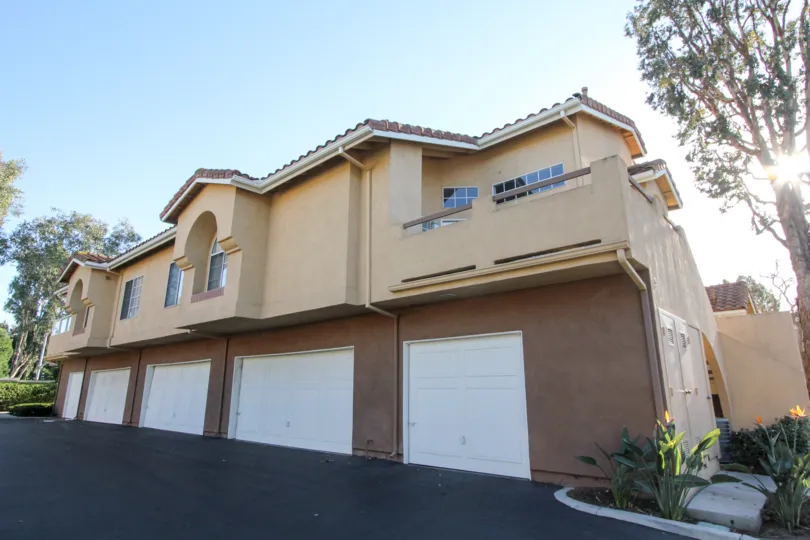 A row of garages and a building in the Westpark Tiempo community on a sunny day