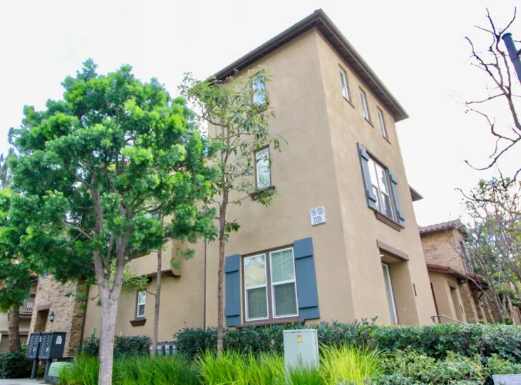 A two-and-a-half storey unit in Whispering Glen community with beige walls and blue shutters.