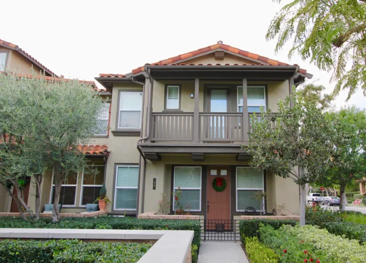 A two story brown building with brown doors behind sidewalk at Whispering Glen in Irvine CA